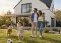 Famille heureuse devant une maison moderne